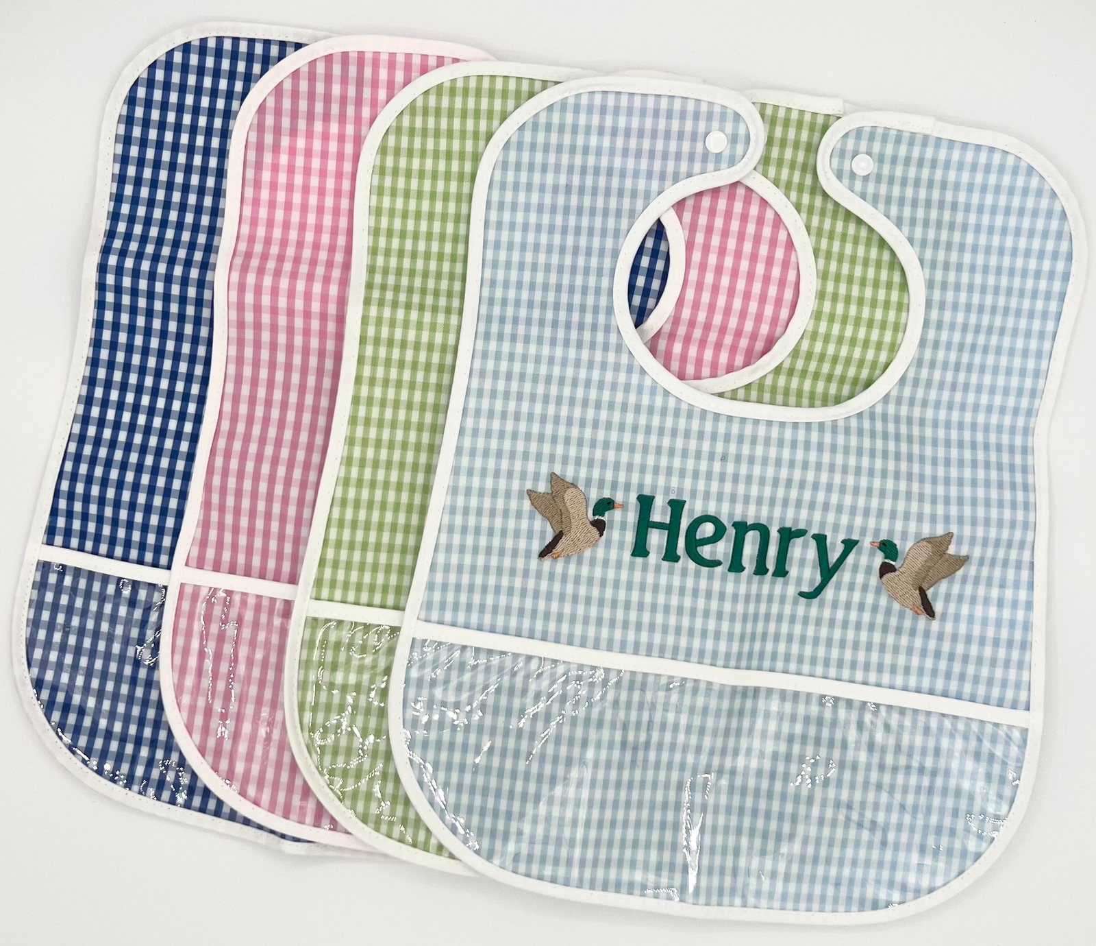 Set of four baby bibs with 'Henry' branding on a white background